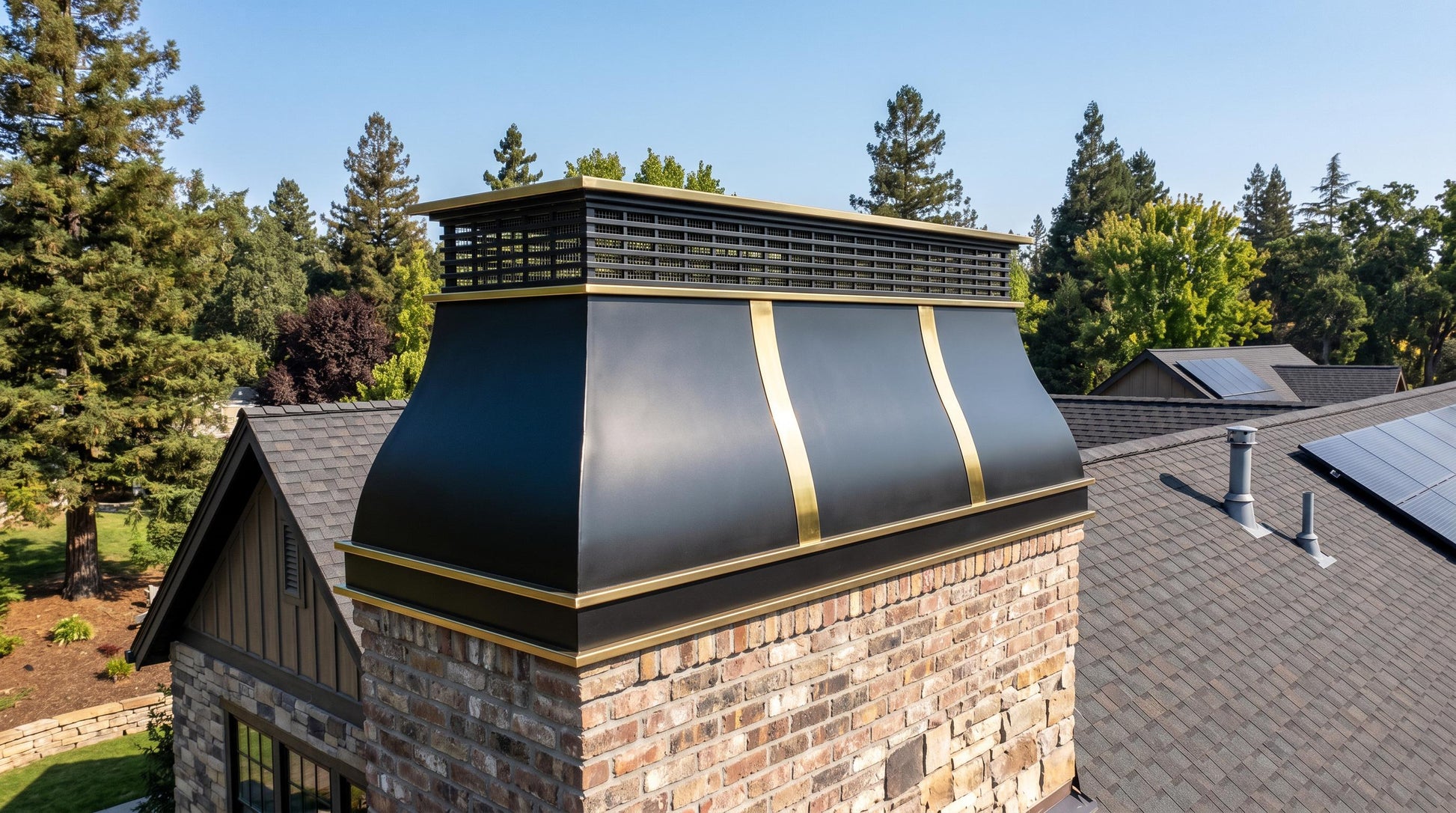 Custom stainless steel chimney crown with decorative brass accents, handmade with seamless welded construction for residential masonry chimneys.